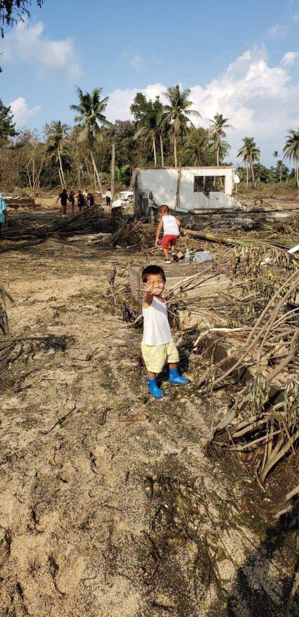 A Tongan boy stands amongst destruction in wake of eruption